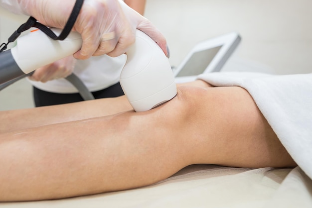 Depilazione sulle gambe procedura laser presso la clinica medica belle gambe femminili lisce in un salone di bellezza spa concept banner per la cura della pelle del laser