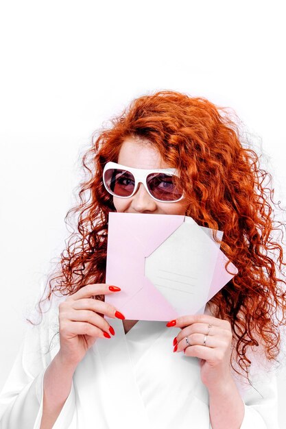 Foto servizi di rimozione dei capelli cura di sé e bellezza certificato regalo nelle mani di una ragazza dai capelli rossi