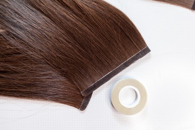Hair ribbons for extensions on a woman's head at home. Hair extensions to thicken your own.