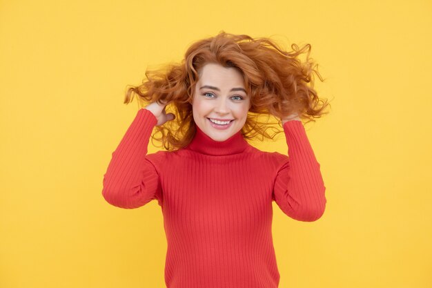 Hair salon. Portrait of beautiful cheerful redhead girl curly redhead hair smiling laughing looking at camera over yellow background