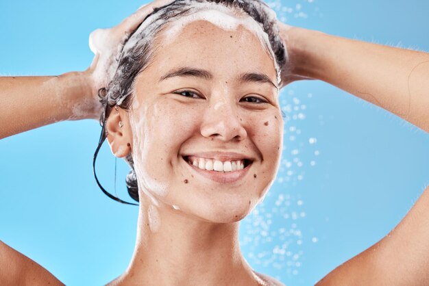 写真 髪のシャンプーの肖像画と青の背景に分離されたスタジオでシャワーを浴びている女性