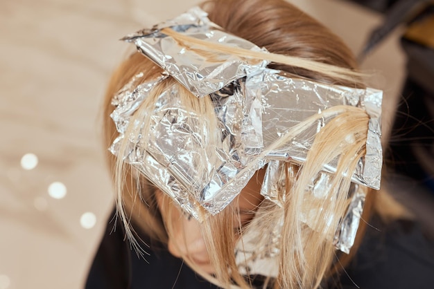 Photo hair stylist makes bouffant using comb on thin strands. shatush technique for hair lightening.