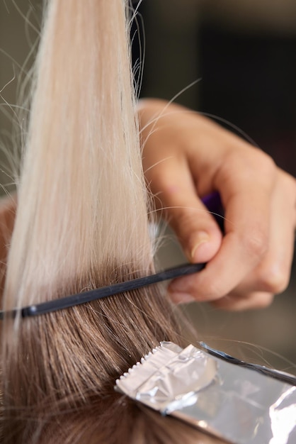 헤어 스타일리스트는 얇은 가닥에 빗을 사용하여 부풀려진 머리카락을 밝게 만드는 샤투시(Shatush) 기술