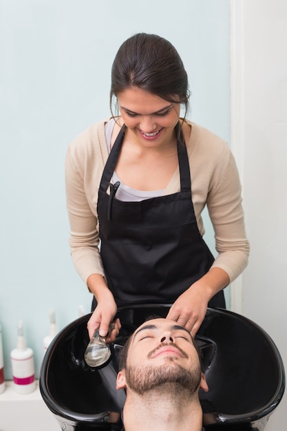 Hair stylist washing mans hair