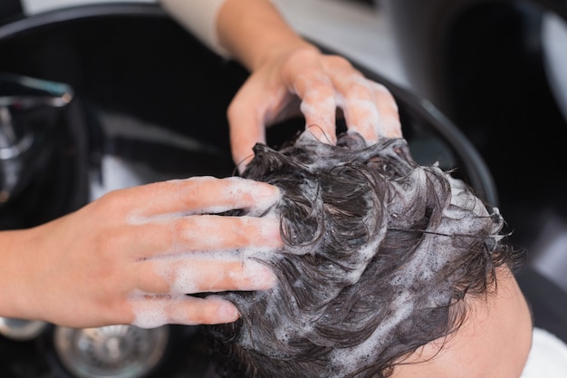 Photo hair stylist washing mans hair