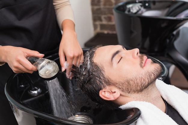 Hair stylist washing mans hair