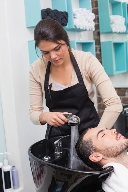 Hair stylist washing mans hair