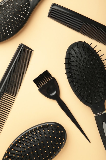 Hair tools, beauty and hairdressing concept - different brushes or combs on beige surface