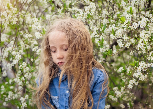 Hair in the wind close the girl's face in the cherry orchard.