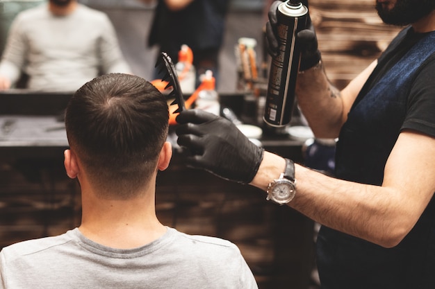 Testa di taglio di capelli nel barbiere. il barbiere taglia i capelli sulla testa del cliente. il processo di creazione di acconciature per uomo. barbiere. messa a fuoco selettiva.