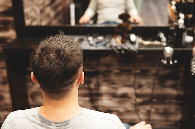 Haircut head in barbershop, Barber cuts the hair on the head of the client.