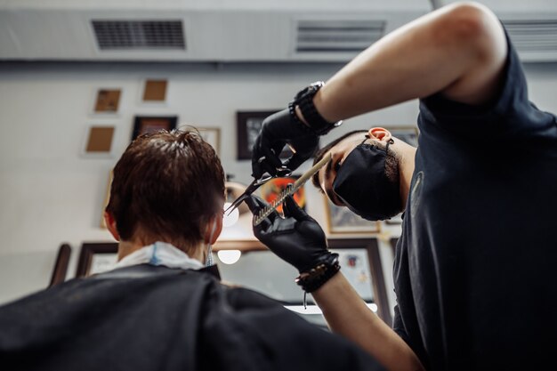 Taglio di capelli in nuove condizioni. novità nel mondo della moda. taglio di capelli maschile in un negozio di barbiere, salone di bellezza.