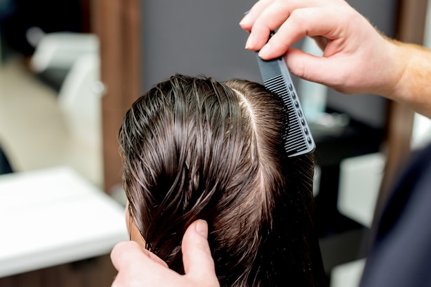 haircut of woman's hair in hair salon.
