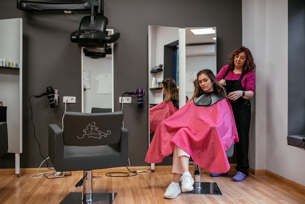 Foto parrucchiere che pettina i capelli della donna