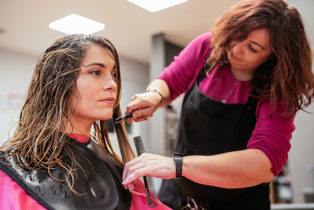 Hairdresser combing woman's hair