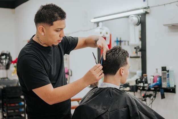 Foto il parrucchiere taglia e pettina i capelli del suo cliente