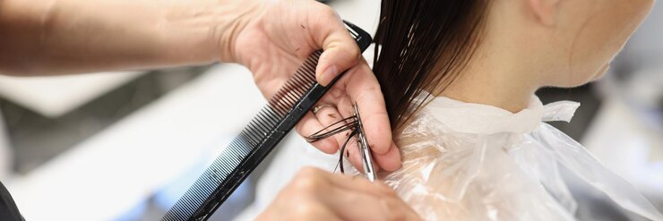 Hairdresser cuts cut ends of hair in beauty salon