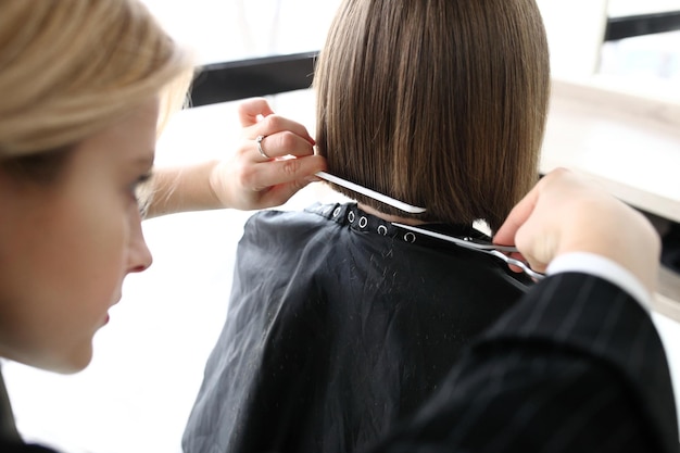 Hairdresser cutting hair in salon closeup