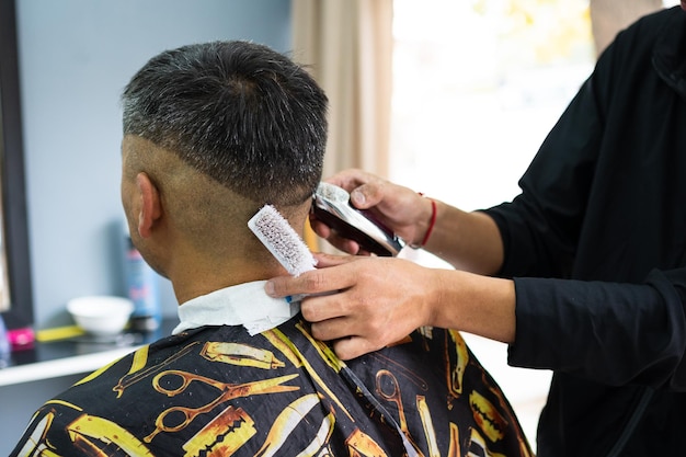 Hairdresser cutting a man's hair as seen from behind