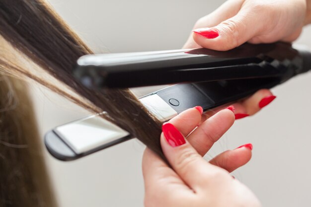 Hairdresser does hair style of woman