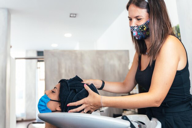 Hairdresser drying a client's hair with a towel