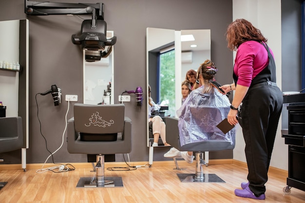 Parrucchiere che tinge i capelli di una donna