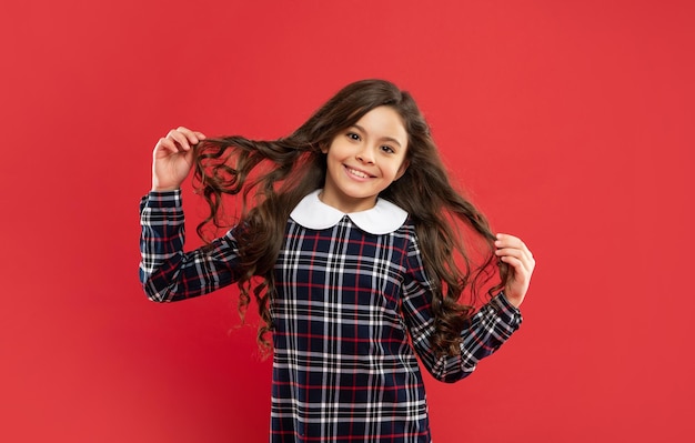 Hairdresser. glad kid with curly hair. teen beauty hairstyle. female fashion model. frizzy hair curl. girl has wavy hairdo. portrait of frizz child. express positive emotion. haircare and skincare.