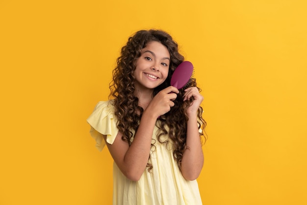 Hairdresser kid smile with curly hair hold hairbrush teen beauty hairstyle