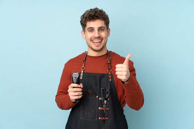 Hairdresser man isolated on blue background giving a thumbs up gesture