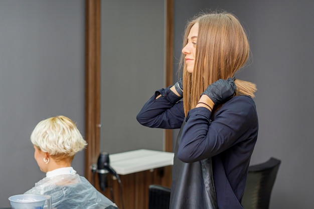 Hairdresser puts on black apron