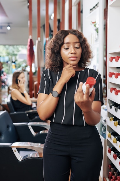 Hairdresser reading directions on shampoo bottle