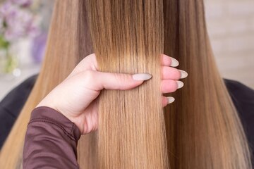 Premium Photo | Hairdresser's hand brushing long natural blonde hair in  beauty salon