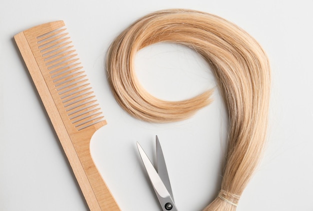 Photo hairdresser's scissors with strand of blonde hair