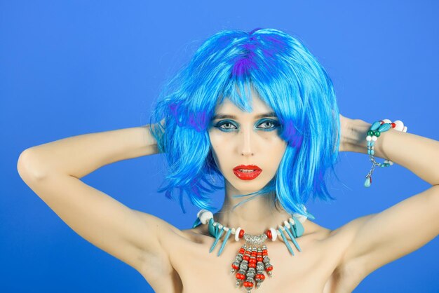 Hairdresser salon and barbershop Beauty and fashion Girl with bright artificial hair in ethnic jewelry Woman in blue wig with fashionable makeup Fashion model with naked body and red lips