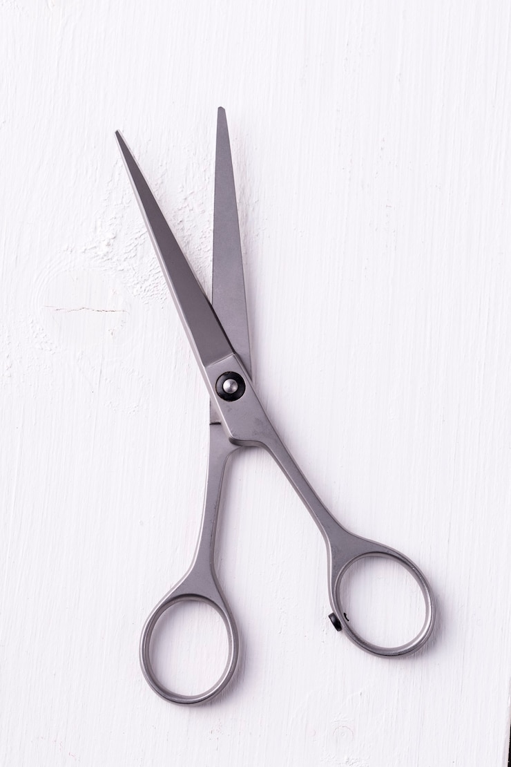 Photo hairdresser scissors shot on top of the white wooden background