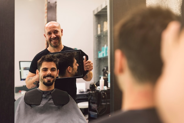 Hairdresser showing his work through the mirror