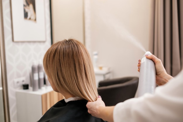 Parrucchiere che acconcia i capelli e fa la cura dei capelli