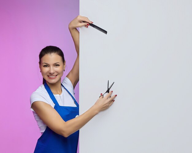 Hairdresser stylist of Asian appearance poses with a white Billboard. advertising concept