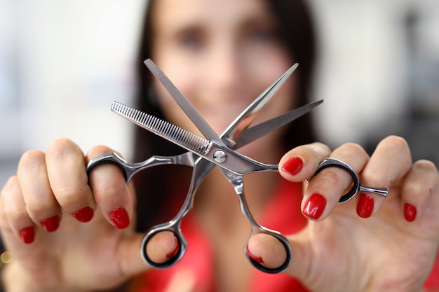 Hairdresser woman hold scissors closeup