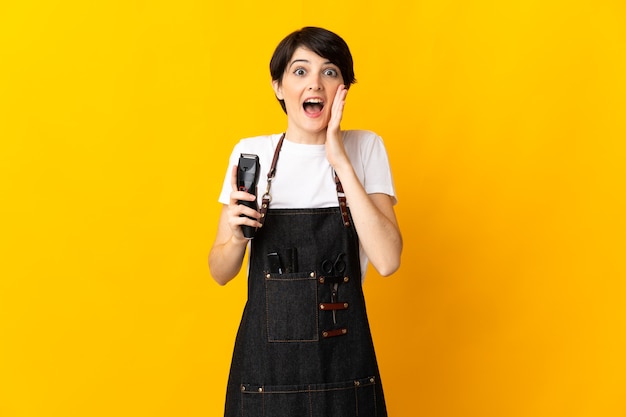 Hairdresser woman on yellow with surprise and shocked facial expression