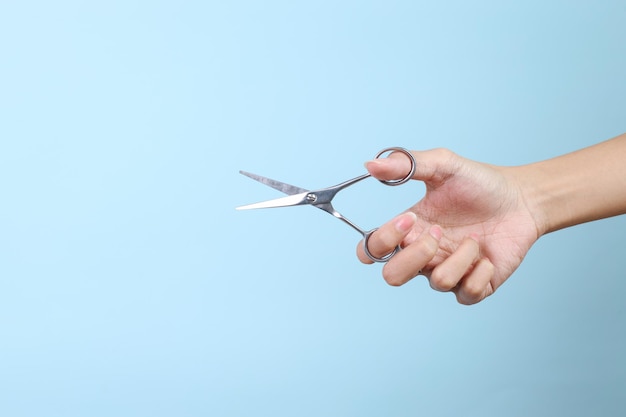 Hairdressers Hand with Scissors Isolated On Blue Background