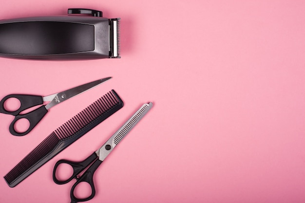Premium Photo | Hairdressing hair cutting tools on a pink background top  view, copy space.