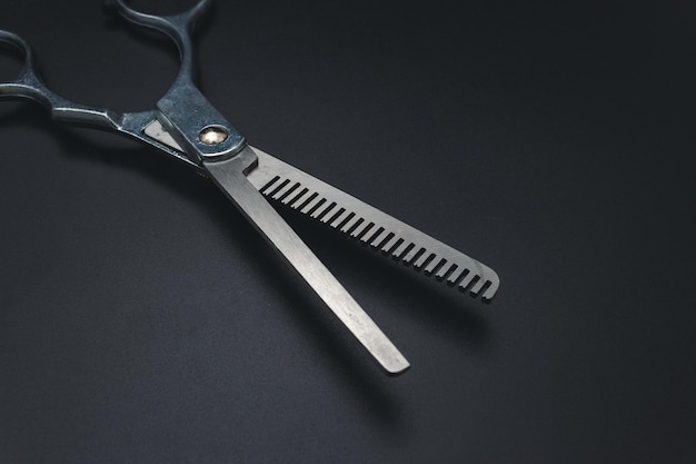写真 黒い背景のヘアドレッシングの剪刀 スタイリッシュなプロの理 ⁇ 師の剪刀 ツールケアの剪刀の磨き