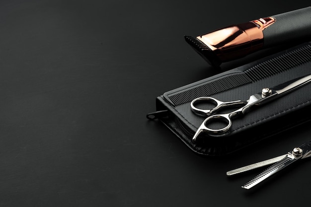 Ножницы для парикмахерской с чемоданом на черном фоне