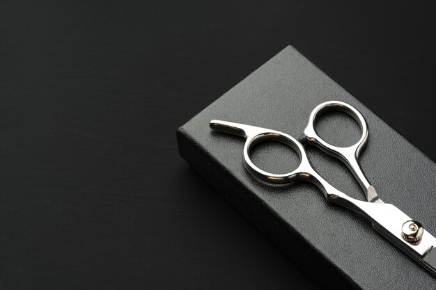 Photo hairdressing scissors with case on a black background