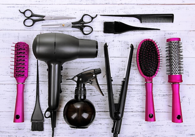 Photo hairdressing tools on white wooden table closeup