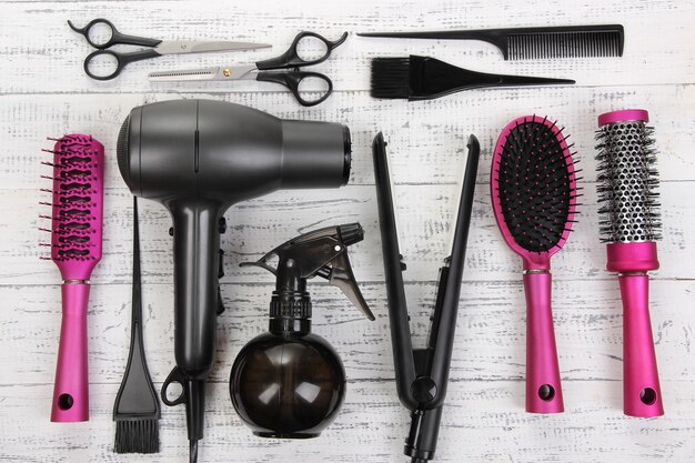 Photo hairdressing tools on white wooden table closeup