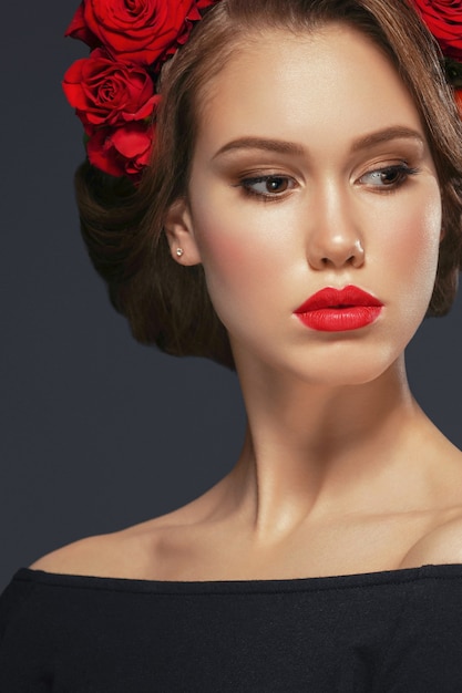 Hairstyle with Roses Flowers Woman Glamour Beauty Portrait. Studio shot.