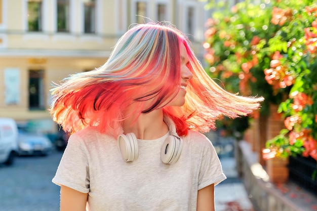 Hairstyles, hairs, fashion, trends, coloring. Close-up of fluttering colored dyed hair of young woman on sunny city street