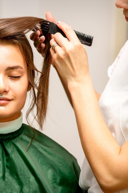 hairstyling bride a female hairdresser makes styling hair for the beautiful young caucasian woman in a beauty salon